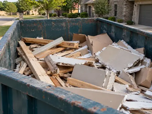 Wood and drywall debris inside a roll-off dumpster