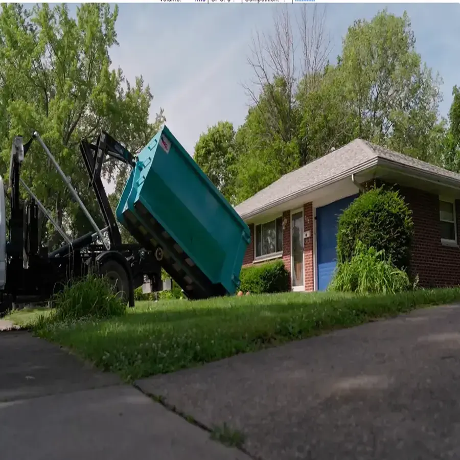 Truck lowering a teal dumpster beside a home in the Fort Sill dumpster rental guide